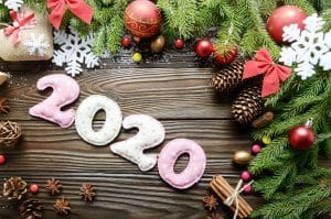 Colorful stitched digits 2020 of polkadot fabric with Christmas decorations flat lay on wooden background